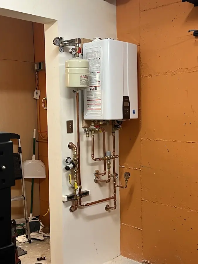 Plumbing technician inspecting water heater connections in Haworth